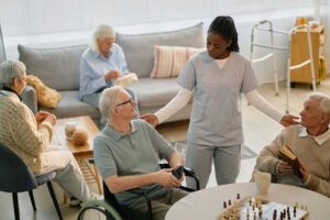 Seniors playing a board game together at a communal table in a bright, comfortable room.