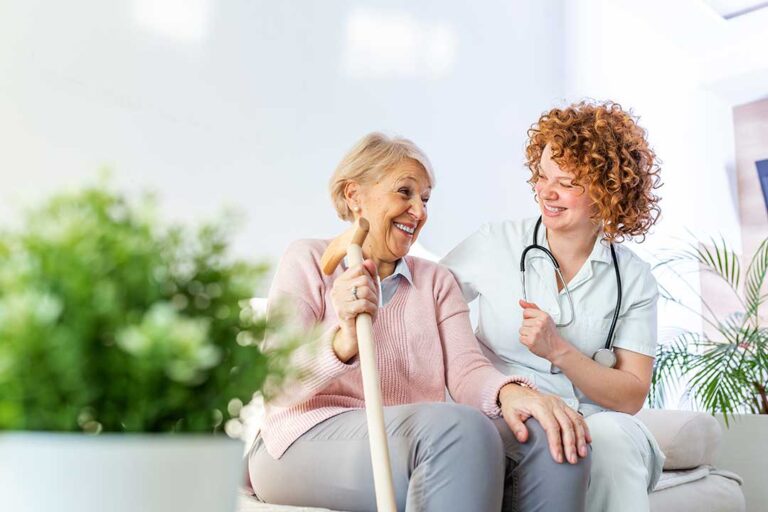 Caregiver reviews a personalized care plan with an older resident at a dining table.